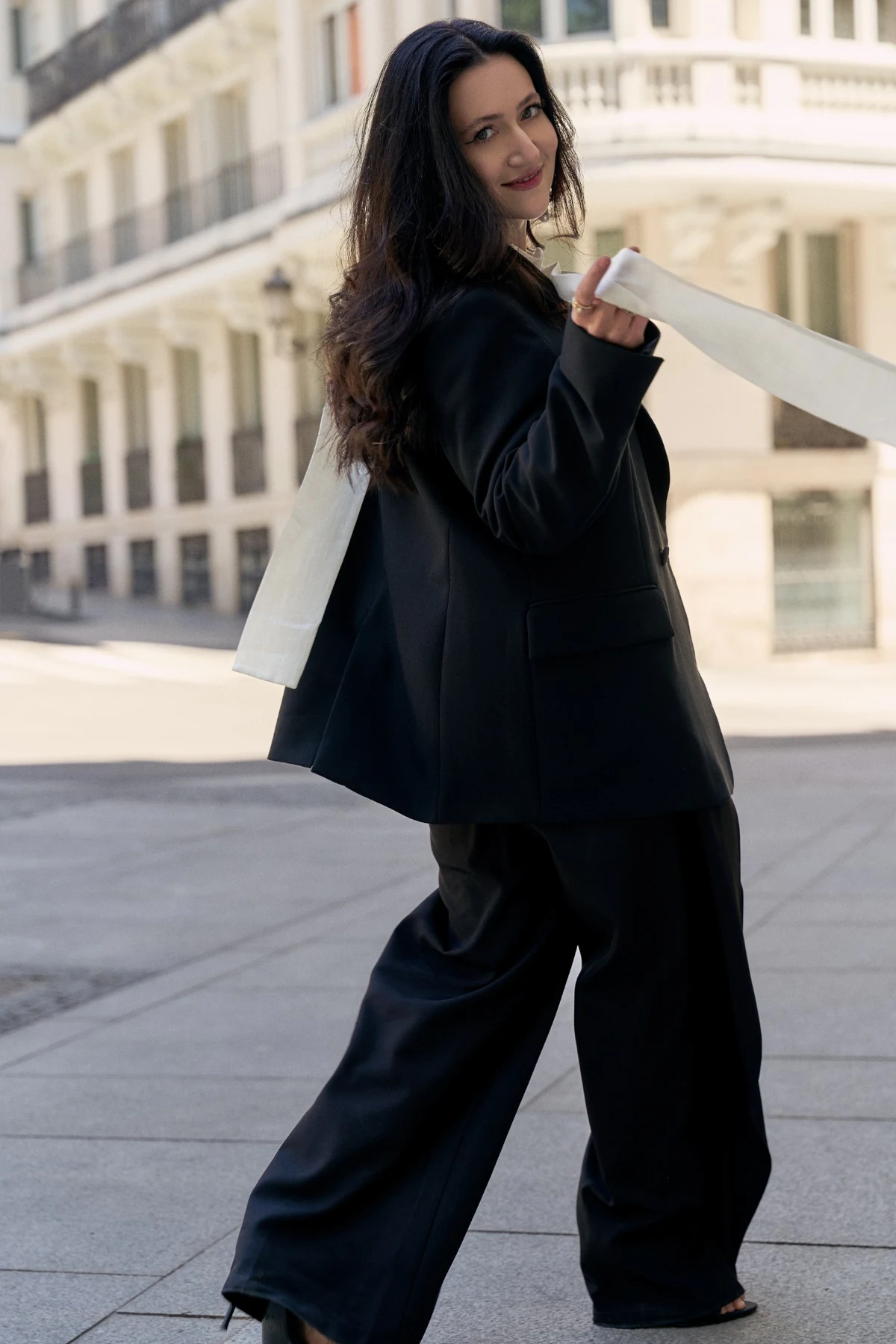 Mané Galoyan in a black suit, outdoors in the city